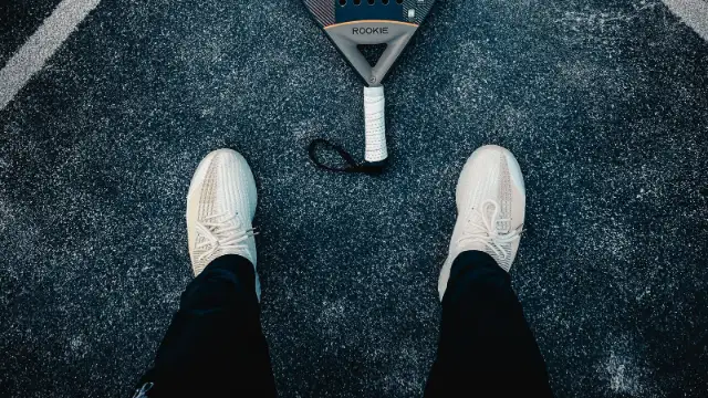 Vista cenital de zapatillas de pádel y pala